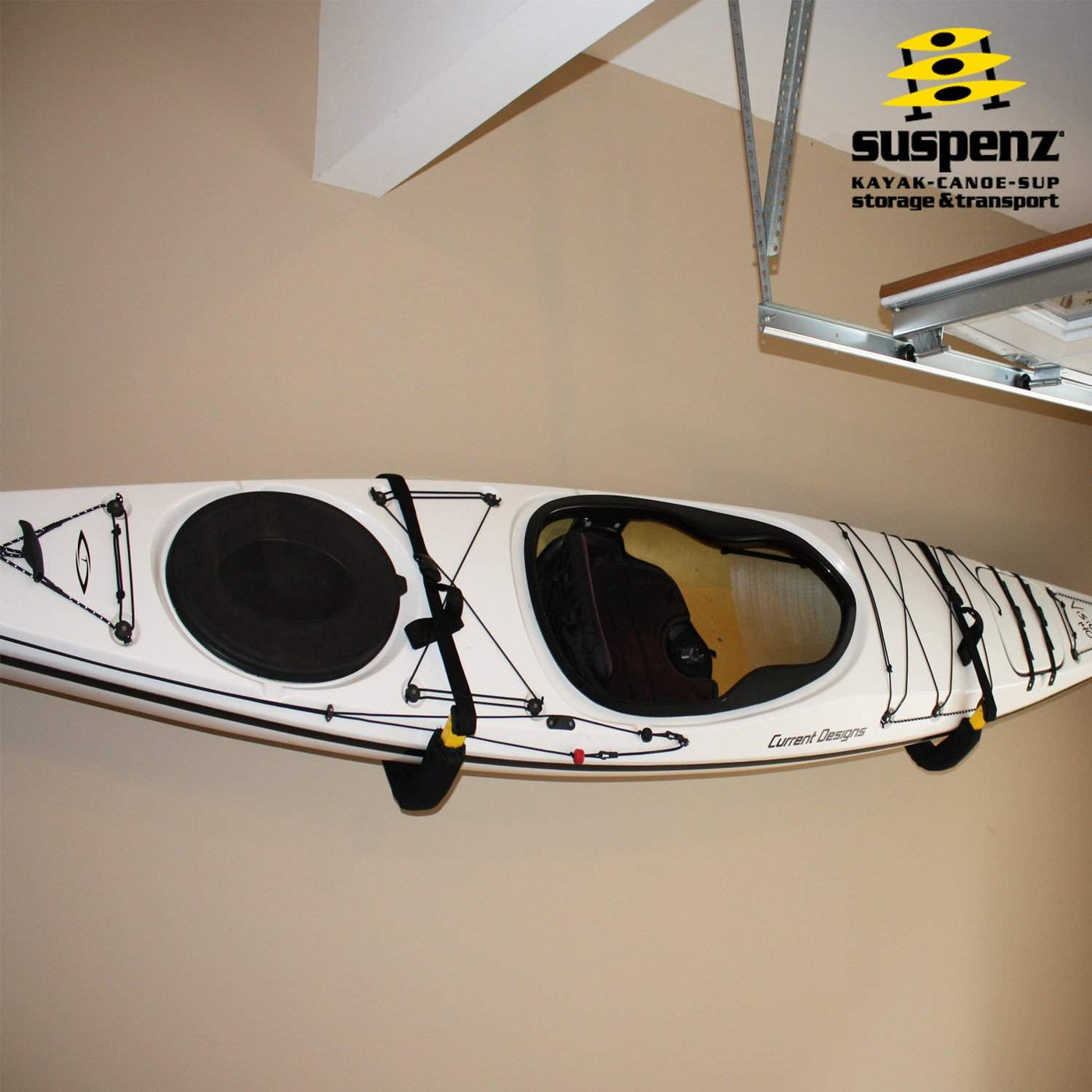 A white kayak resting on an ez rack mounted to a garage wal