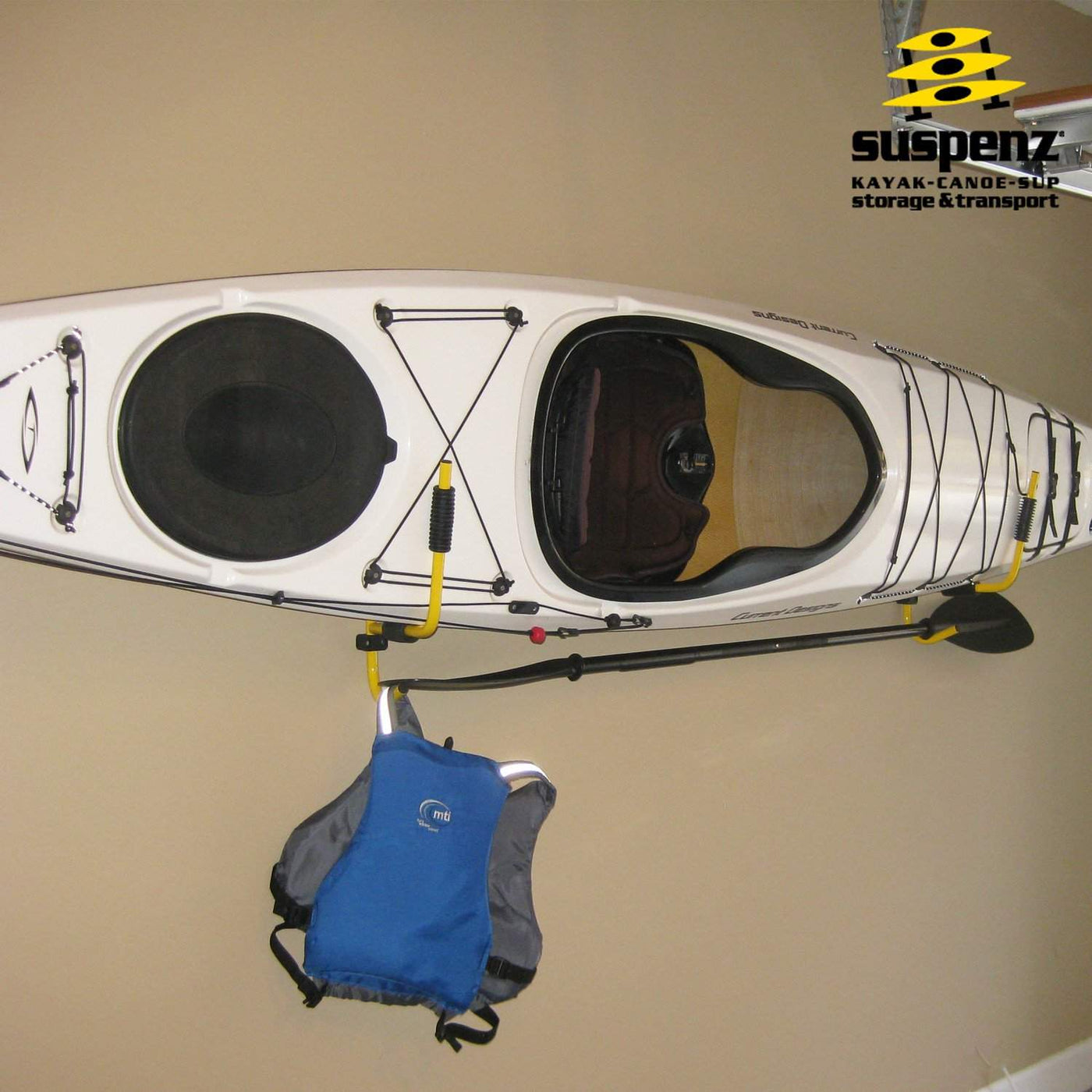 One kayak, one paddle, and one life jacket resting on a folding kayak rack in a garage