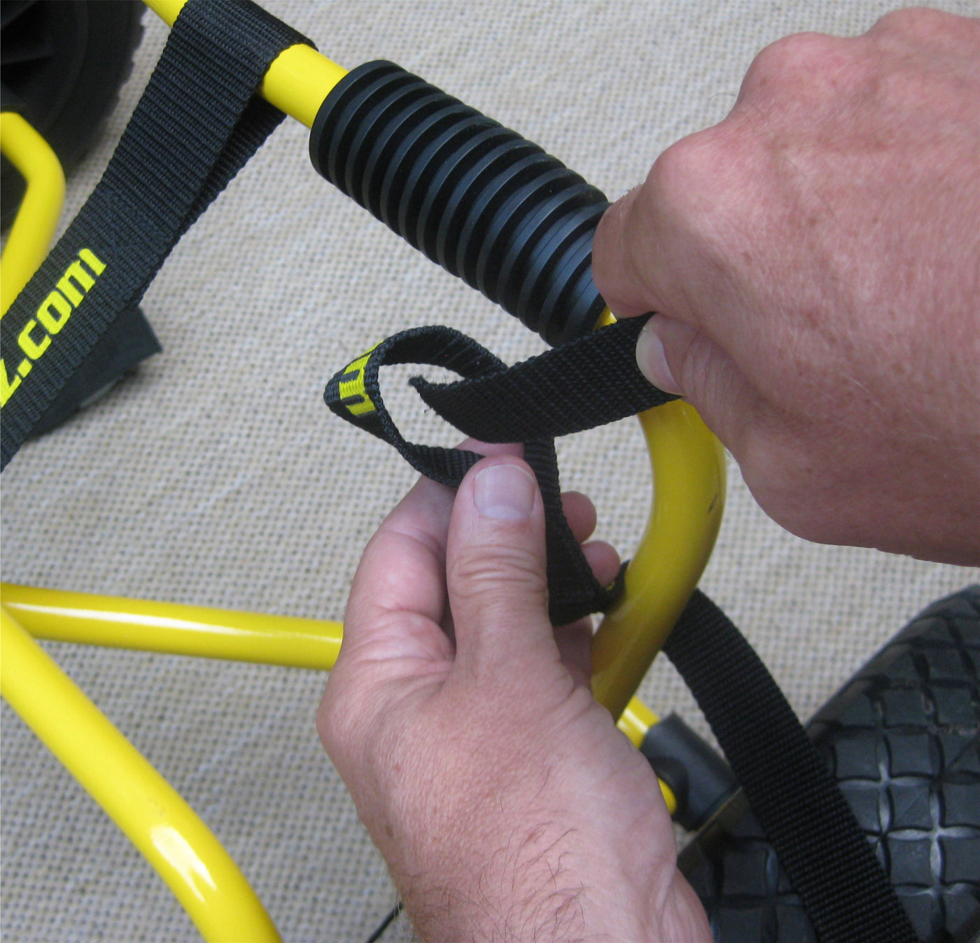 A person tying the straps on the dlx cart