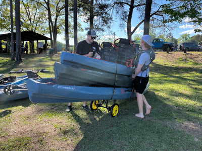 3 kayaks and gear resting on the catch-all universal cart