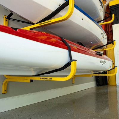 Two kayaks on a suspenz flat rack against a wall.
