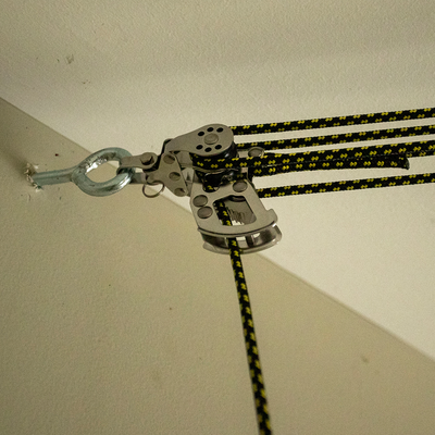 Metal pulley system with ropes on a white wall