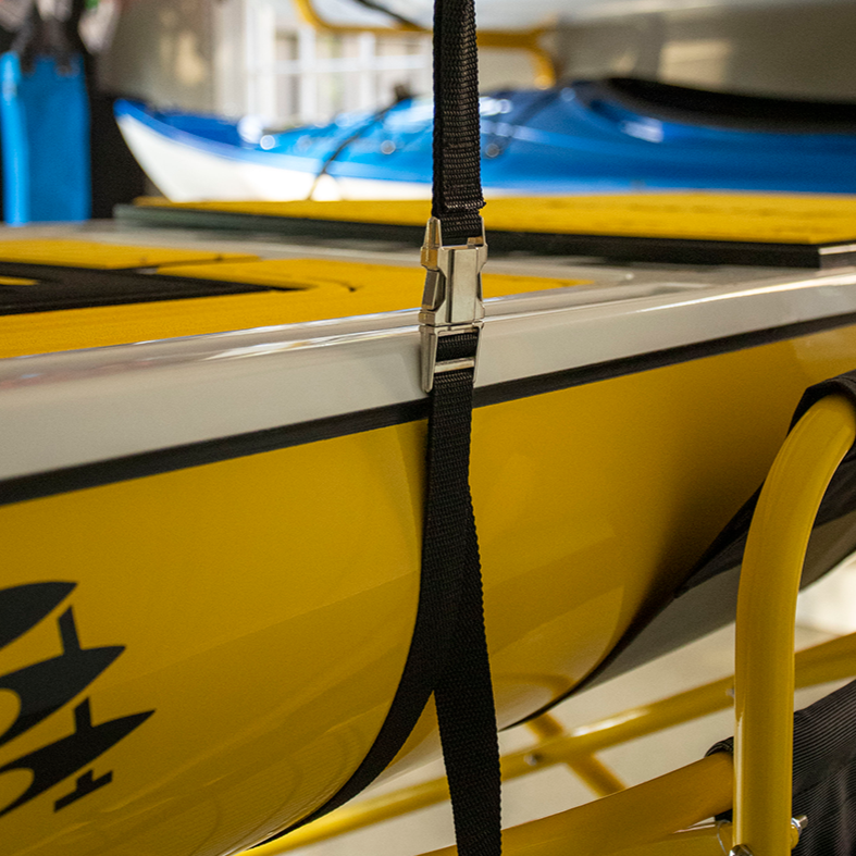 Yellow kayak with a strap attached, with more kayaks in the background.