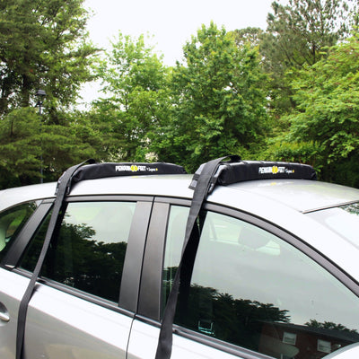 Car with roof rack system installed on a tree-lined street