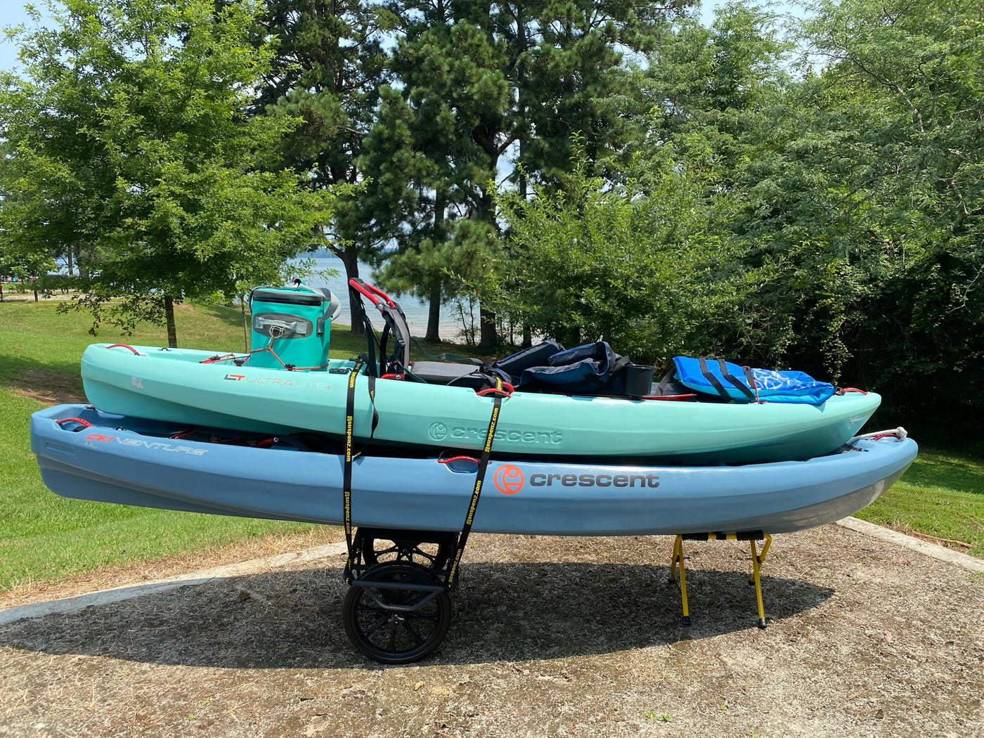 2 kayaks loaded on the All-terrain cart and small universal portable stand