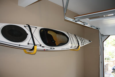 1 kayak mounted on a kayak and canoe wall storage rack in a garage