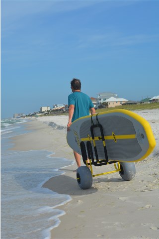 Man pulling a SUP on the double-up SUP beach cart on the beach
