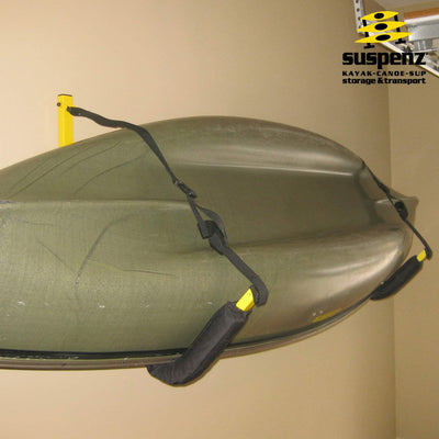 A green canoe resting on the Big EZ mounted to a garage wall