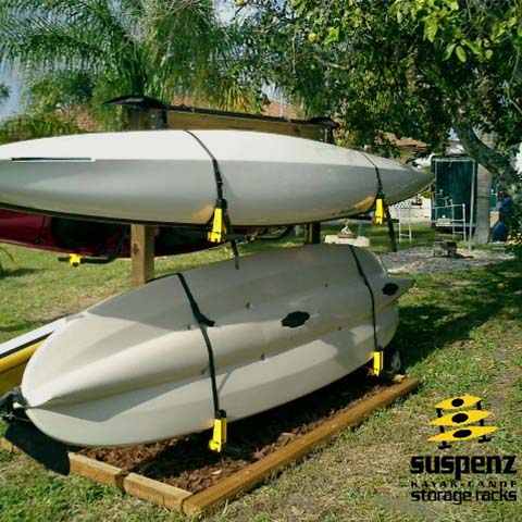 Four Deluxe Racks and boats mounted to wooden posts in a backyard.